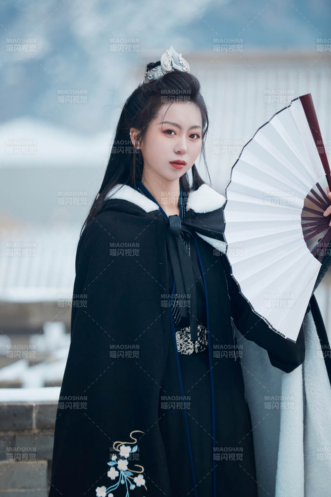 雪天古城身穿汉服扮演武侠的中国少女图片