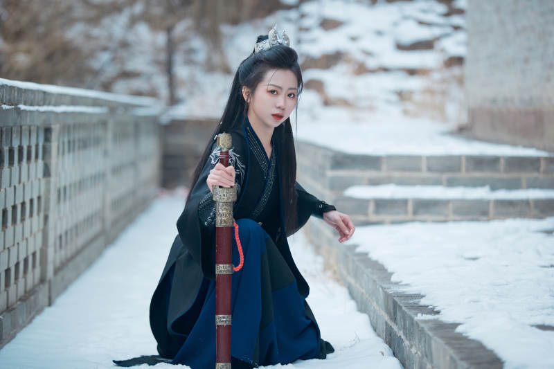 雪天古城身穿汉服扮演武侠的中国少女图片