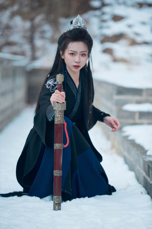 雪天古城身穿汉服扮演武侠的中国少女图片