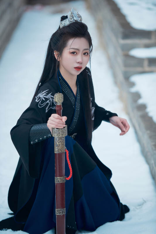 雪天古城身穿汉服扮演武侠的中国少女图片