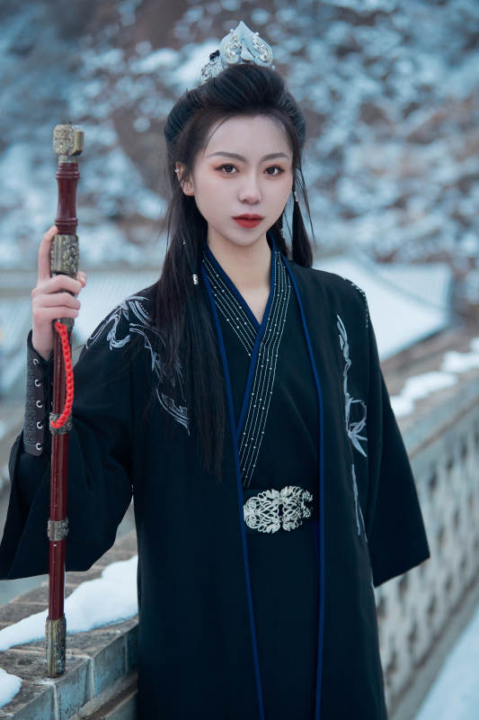 雪天古城身穿汉服扮演武侠的中国少女图片