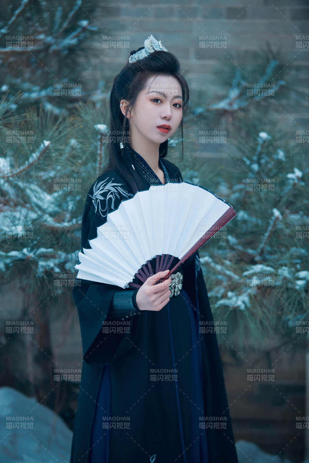雪天古城身穿汉服扮演武侠的中国少女图片