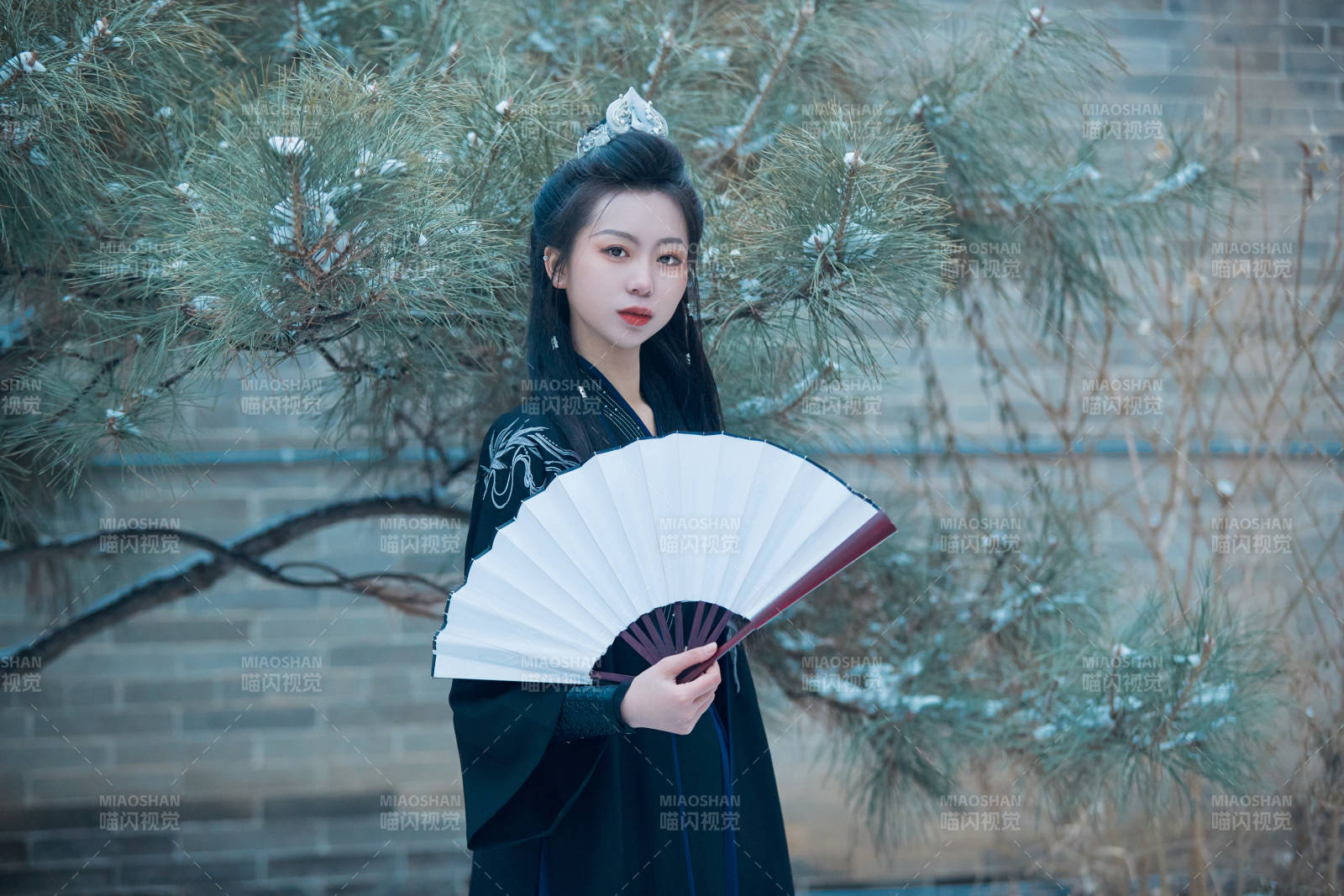 雪天古城身穿汉服扮演武侠的中国少女图片