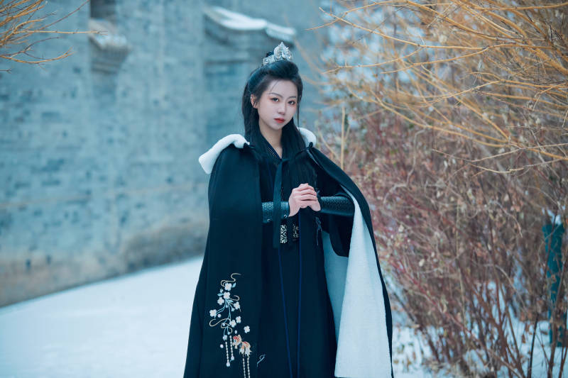 雪天古城身穿汉服扮演武侠的中国少女图片
