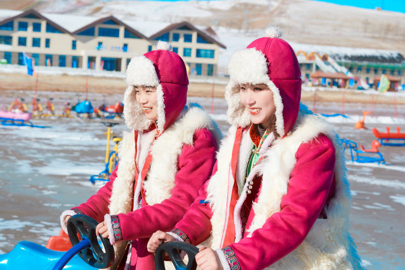 冬天在冻结湖面玩嬉戏滑冰的闺蜜少女图片