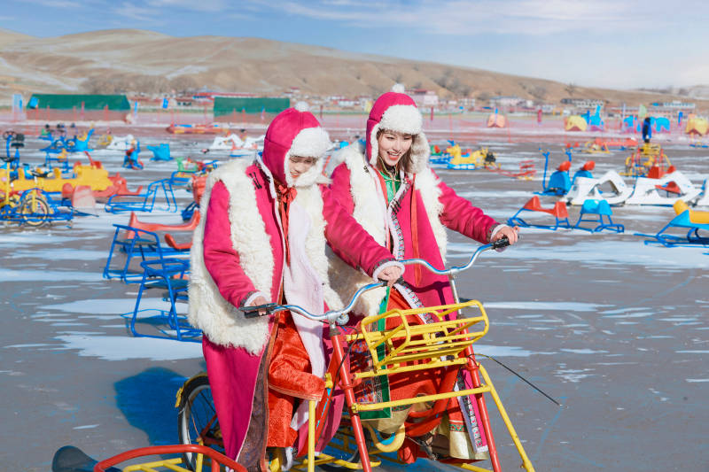 冬天在冻结湖面玩嬉戏滑冰的闺蜜少女图片