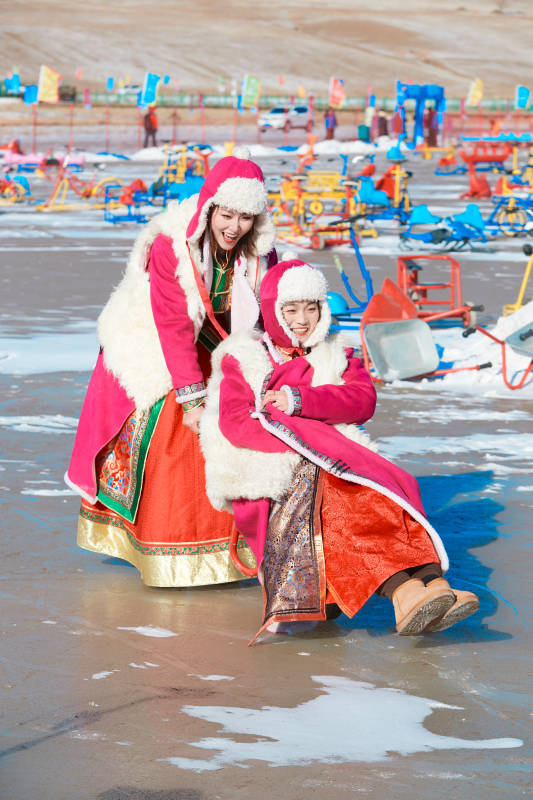 冬天在冻结湖面玩嬉戏滑冰的闺蜜少女图片