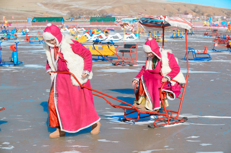 冬天在冻结湖面玩嬉戏滑冰的闺蜜少女图片