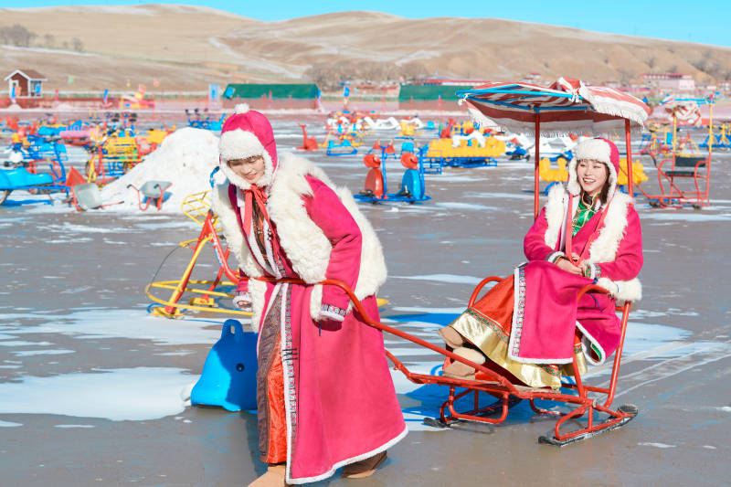 冬天在冻结湖面玩嬉戏滑冰的闺蜜少女图片