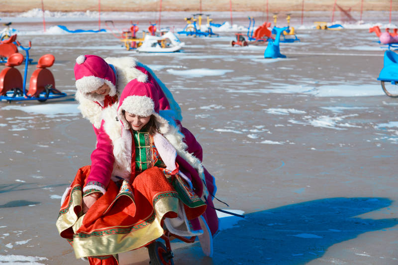 冬天在冻结湖面玩嬉戏滑冰的闺蜜少女图片
