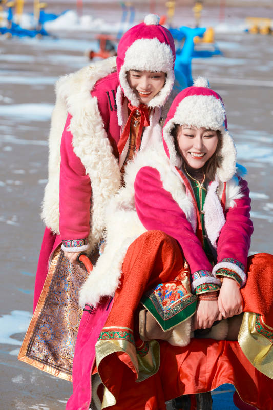 冬天在冻结湖面玩嬉戏滑冰的闺蜜少女图片