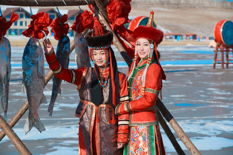 穿着蒙族服饰参加冬季捕鱼活动的闺蜜少女图片