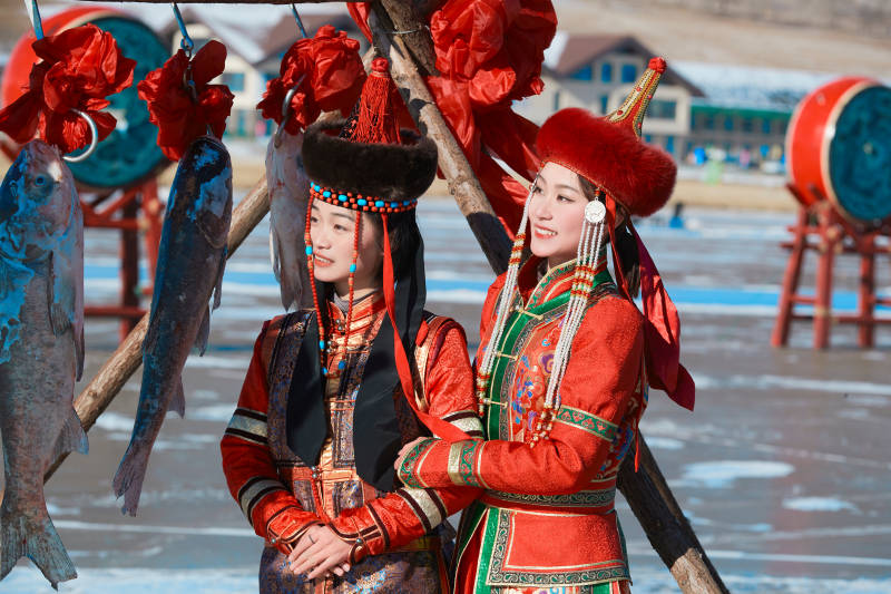 穿着蒙族服饰参加冬季捕鱼活动的闺蜜少女图片