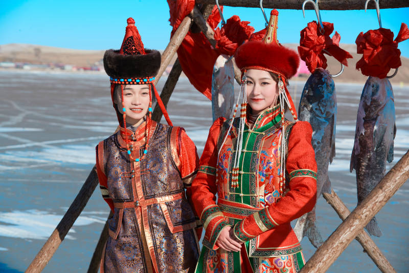 穿着蒙族服饰参加冬季捕鱼活动的闺蜜少女图片