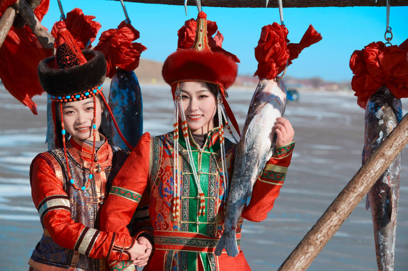 穿着蒙族服饰参加冬季捕鱼活动的闺蜜少女图片