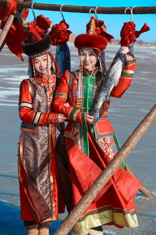 穿着蒙族服饰参加冬季捕鱼活动的闺蜜少女图片