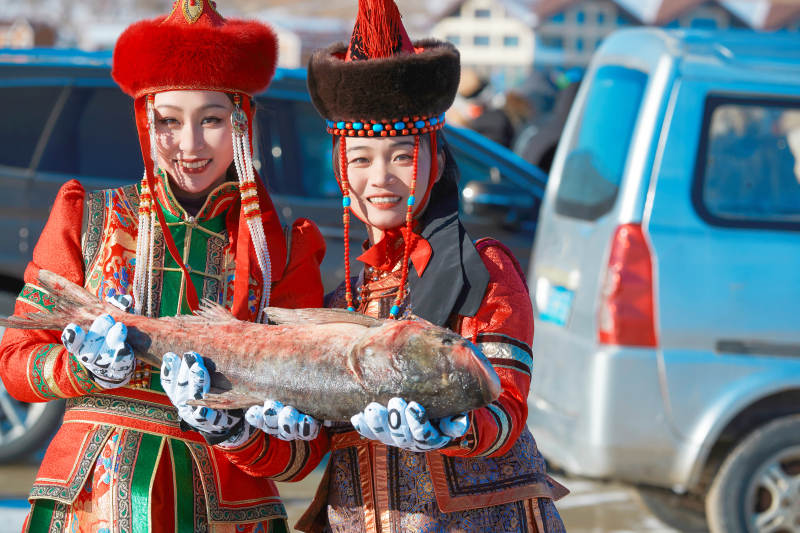 穿着蒙族服饰参加冬季捕鱼活动的闺蜜少女图片