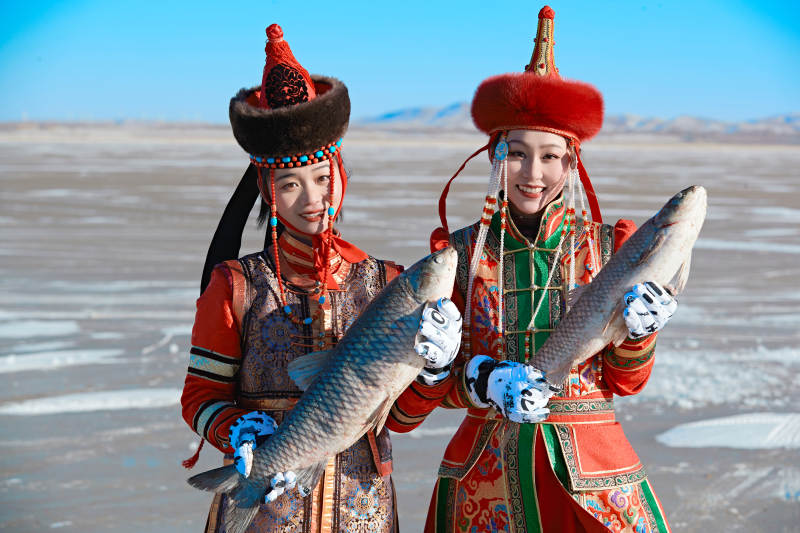 穿着蒙族服饰参加冬季捕鱼活动的闺蜜少女图片