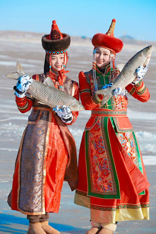 穿着蒙族服饰参加冬季捕鱼活动的闺蜜少女图片