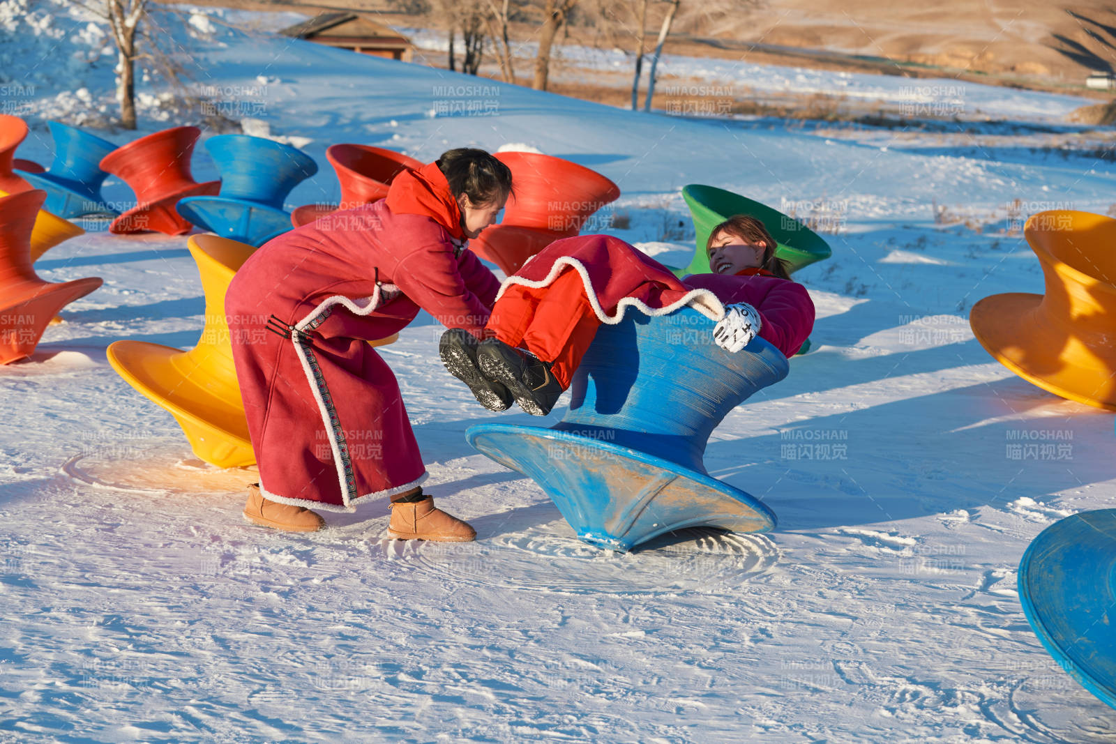 在冰天雪地玩耍雪上娱乐载具车辆的闺蜜少女图片