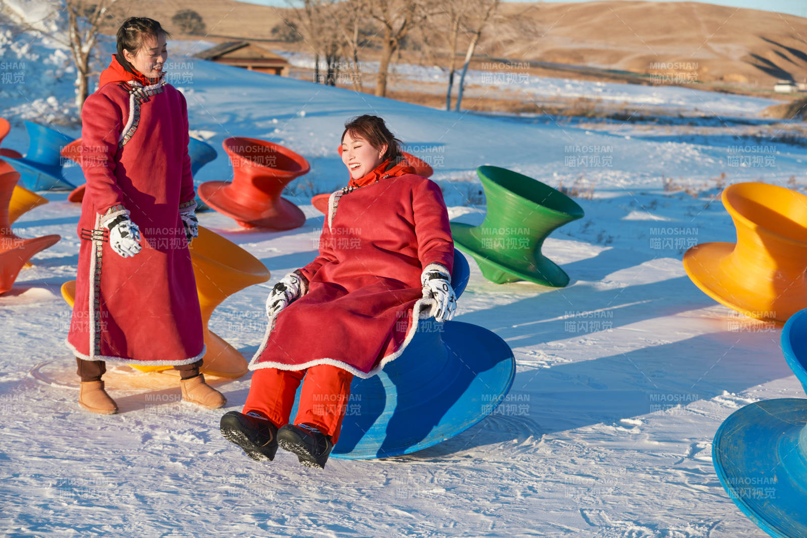 在冰天雪地玩耍雪上娱乐载具车辆的闺蜜少女图片