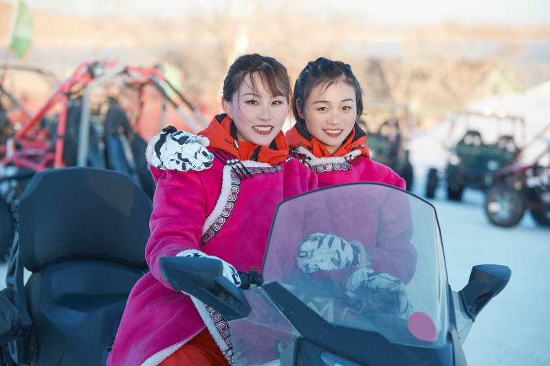 在冰天雪地玩耍雪上娱乐载具车辆的闺蜜少女图片