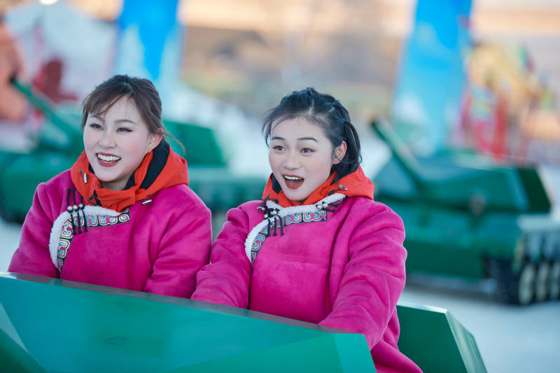 在冰天雪地玩耍雪上娱乐载具车辆的闺蜜少女图片