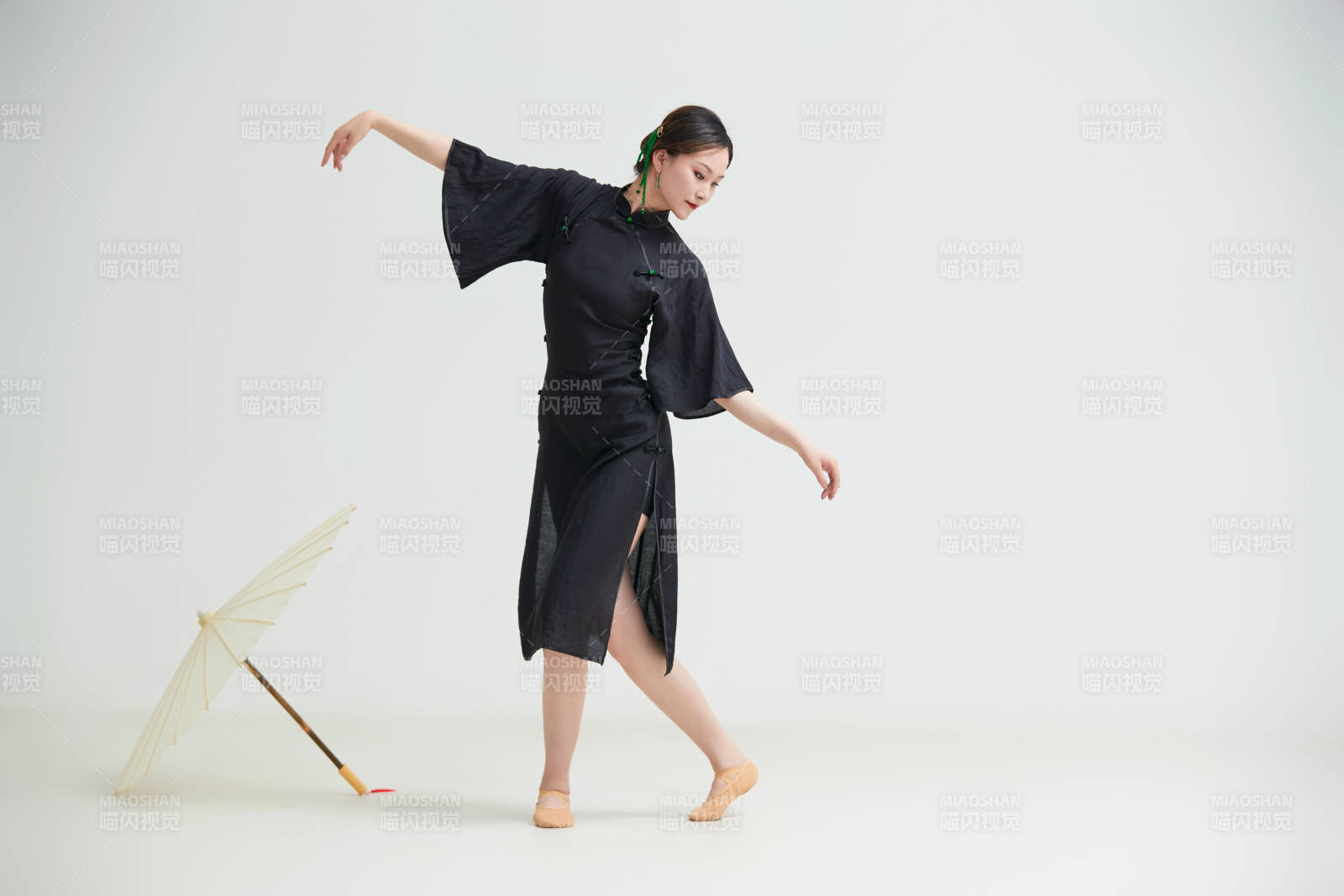 穿中式旗袍手拿油纸伞翩翩舞蹈的亚洲少女舞者图片