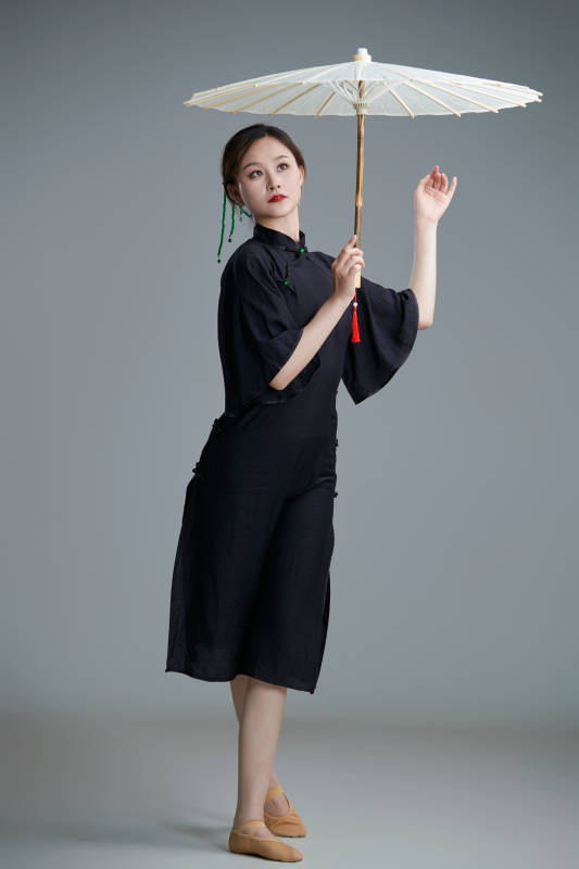 穿中式旗袍手拿油纸伞翩翩舞蹈的亚洲少女舞者图片