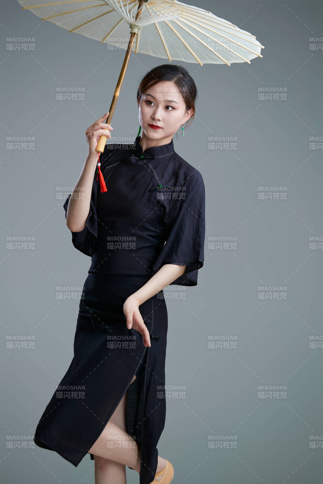 穿中式旗袍手拿油纸伞翩翩舞蹈的亚洲少女舞者图片