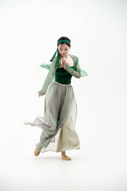 身穿青色古典舞蹈服装手拿蒲扇跳舞的少女图片