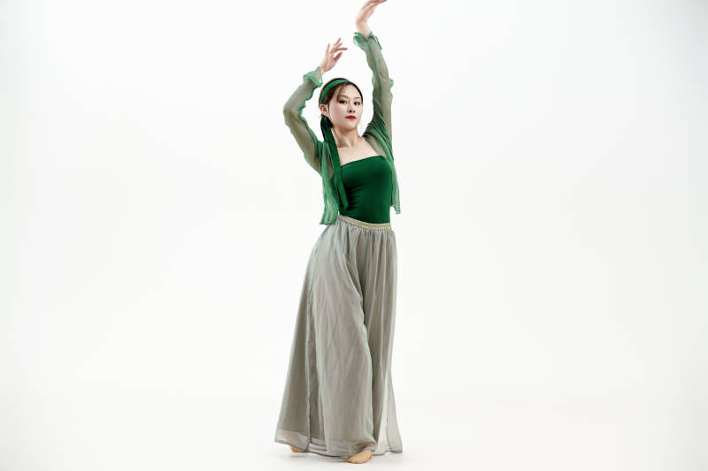 身穿青色古典舞蹈服装手拿蒲扇跳舞的少女图片