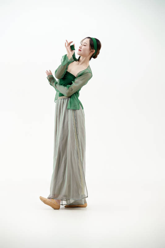 身穿青色古典舞蹈服装手拿蒲扇跳舞的少女图片