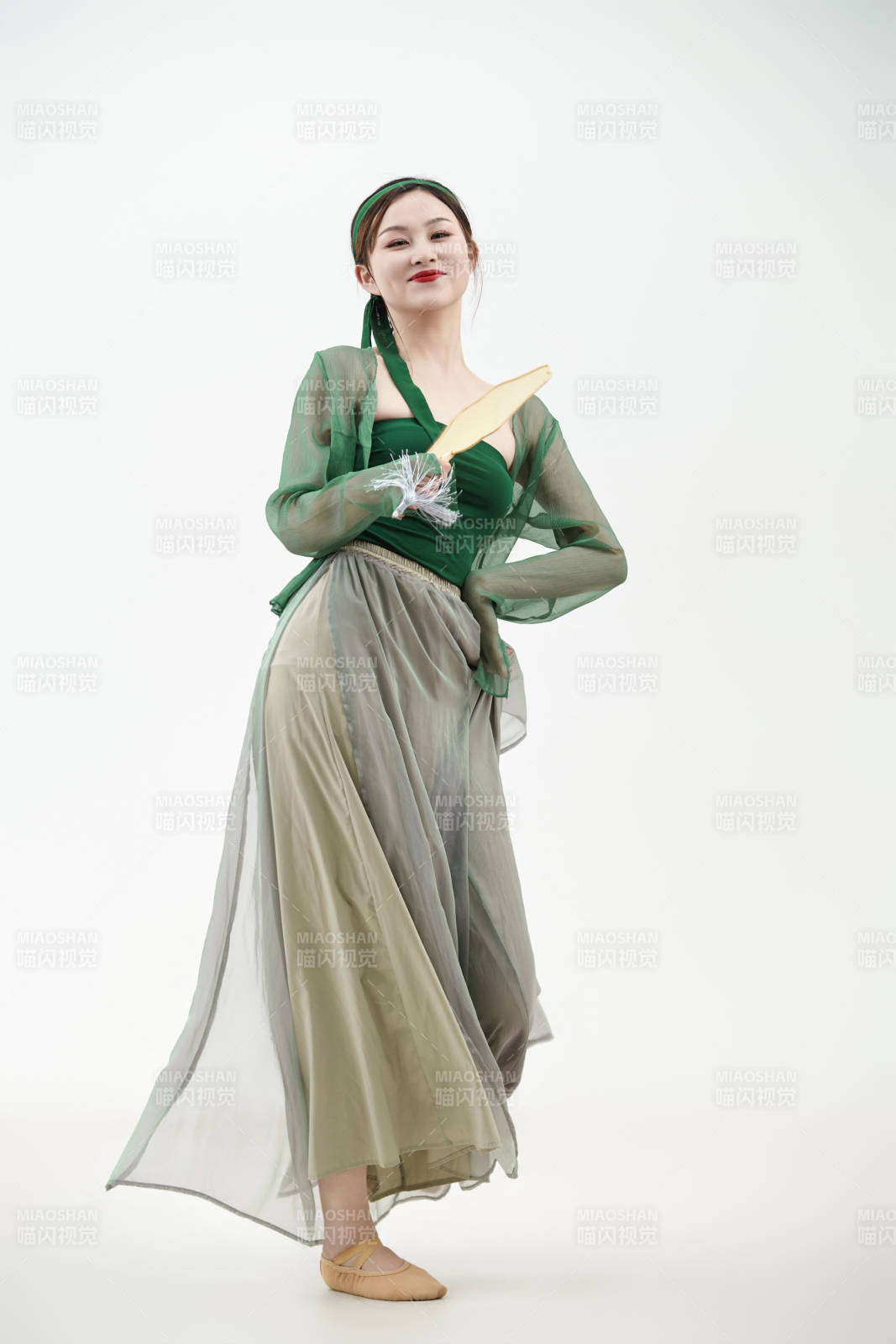 身穿青色古典舞蹈服装手拿蒲扇跳舞的少女图片