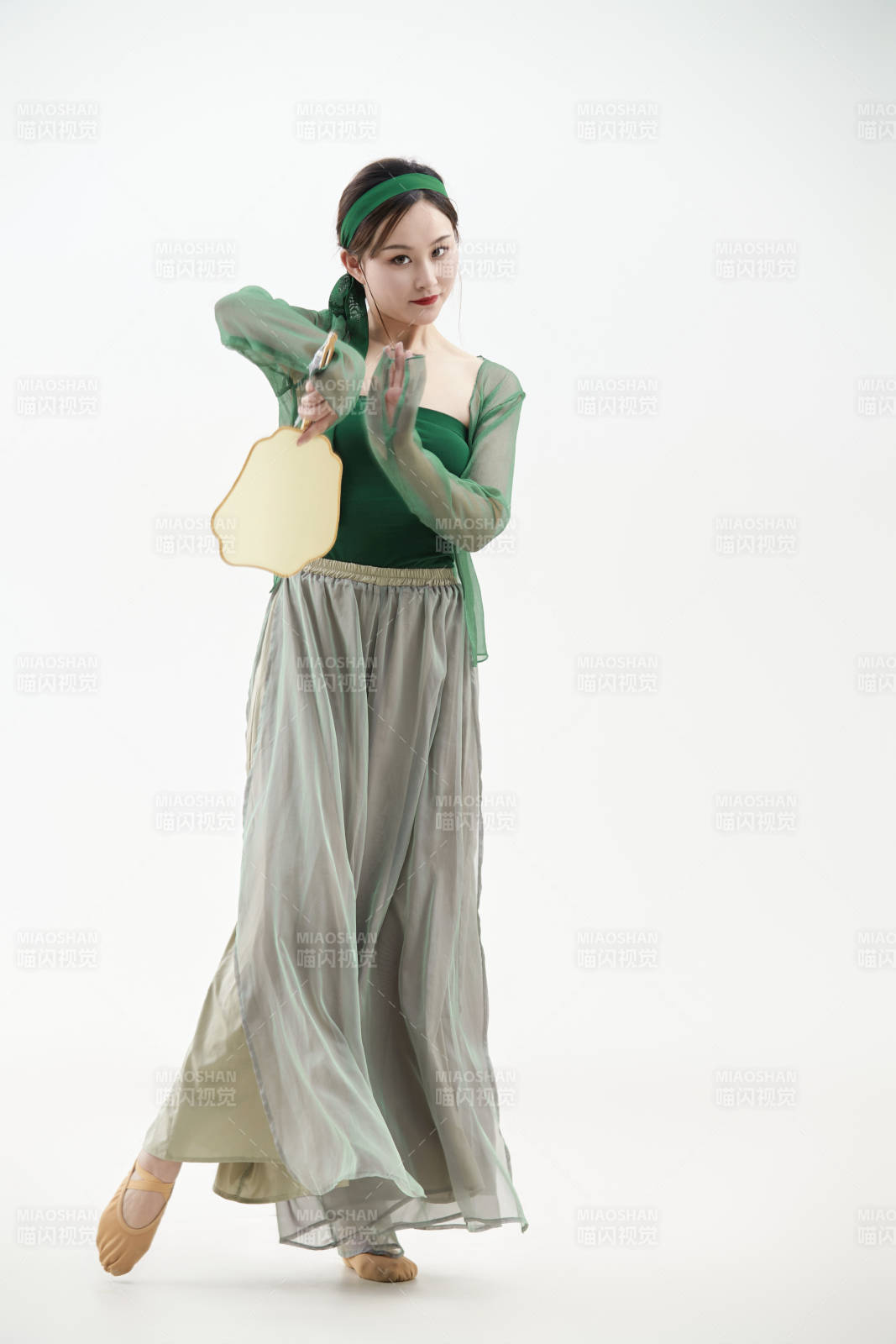 身穿青色古典舞蹈服装手拿蒲扇跳舞的少女图片