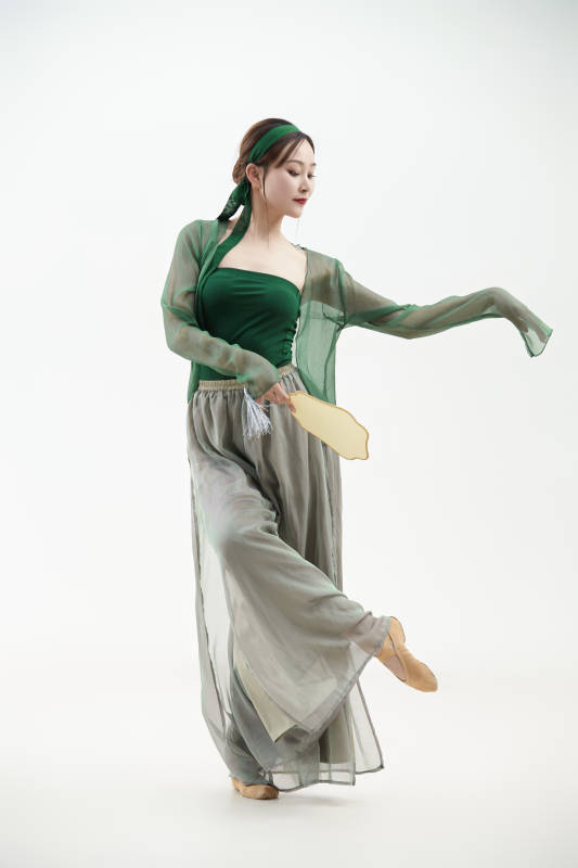 身穿青色古典舞蹈服装手拿蒲扇跳舞的少女图片