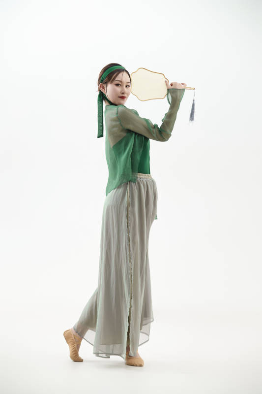 身穿青色古典舞蹈服装手拿蒲扇跳舞的少女图片