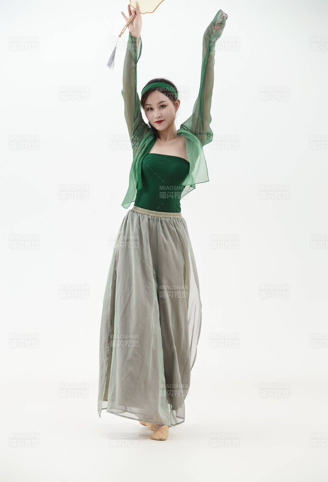 身穿青色古典舞蹈服装手拿蒲扇跳舞的少女图片