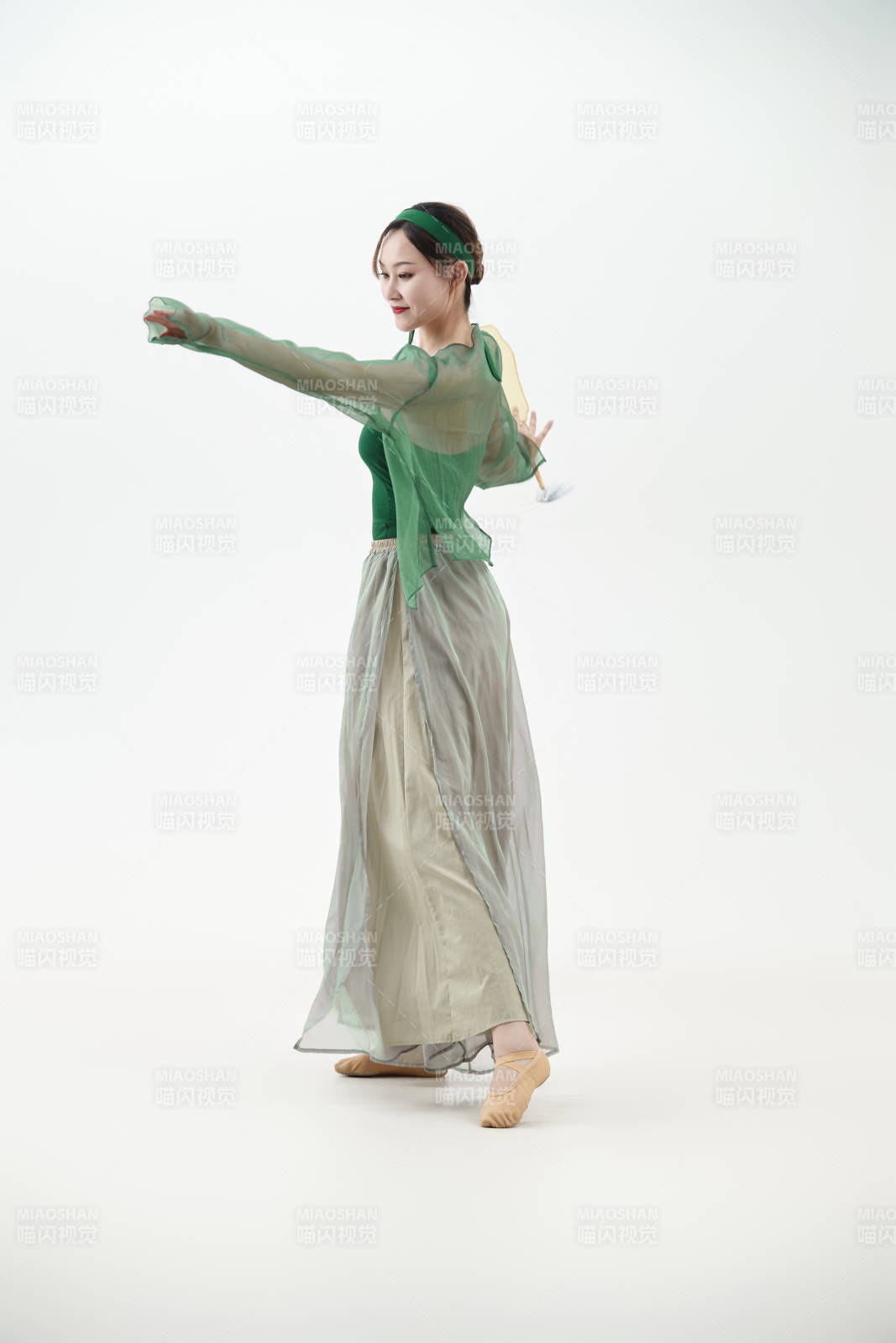 身穿青色古典舞蹈服装手拿蒲扇跳舞的少女图片