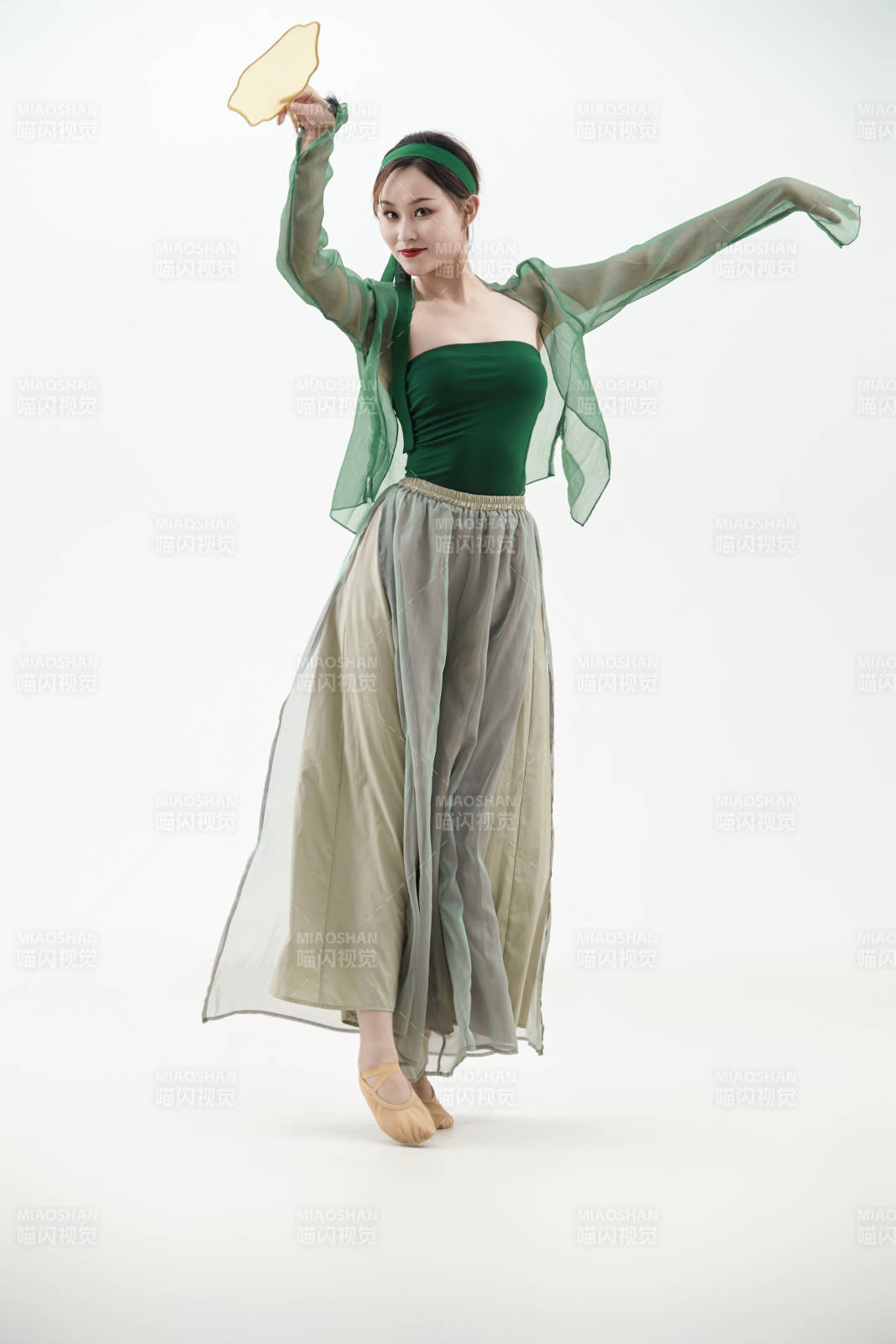 身穿青色古典舞蹈服装手拿蒲扇跳舞的少女图片