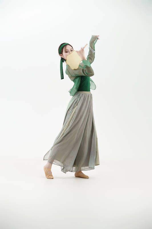 身穿青色古典舞蹈服装手拿蒲扇跳舞的少女图片