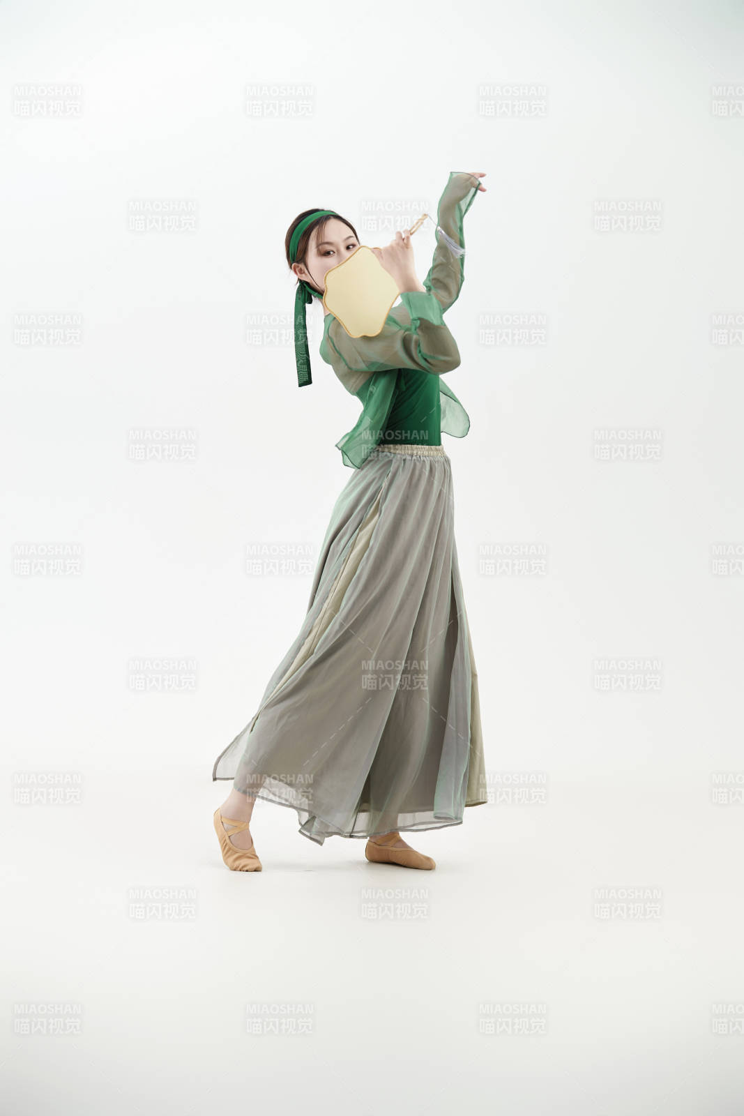 身穿青色古典舞蹈服装手拿蒲扇跳舞的少女图片