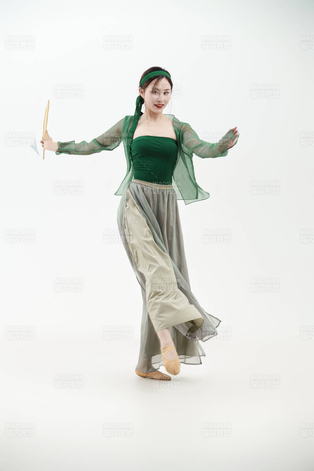 身穿青色古典舞蹈服装手拿蒲扇跳舞的少女图片