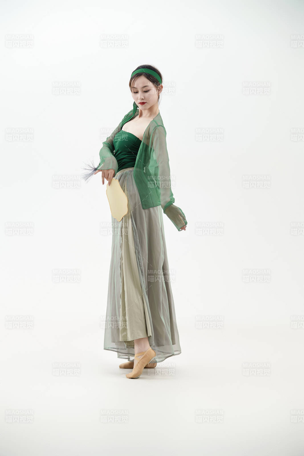 身穿青色古典舞蹈服装手拿蒲扇跳舞的少女图片