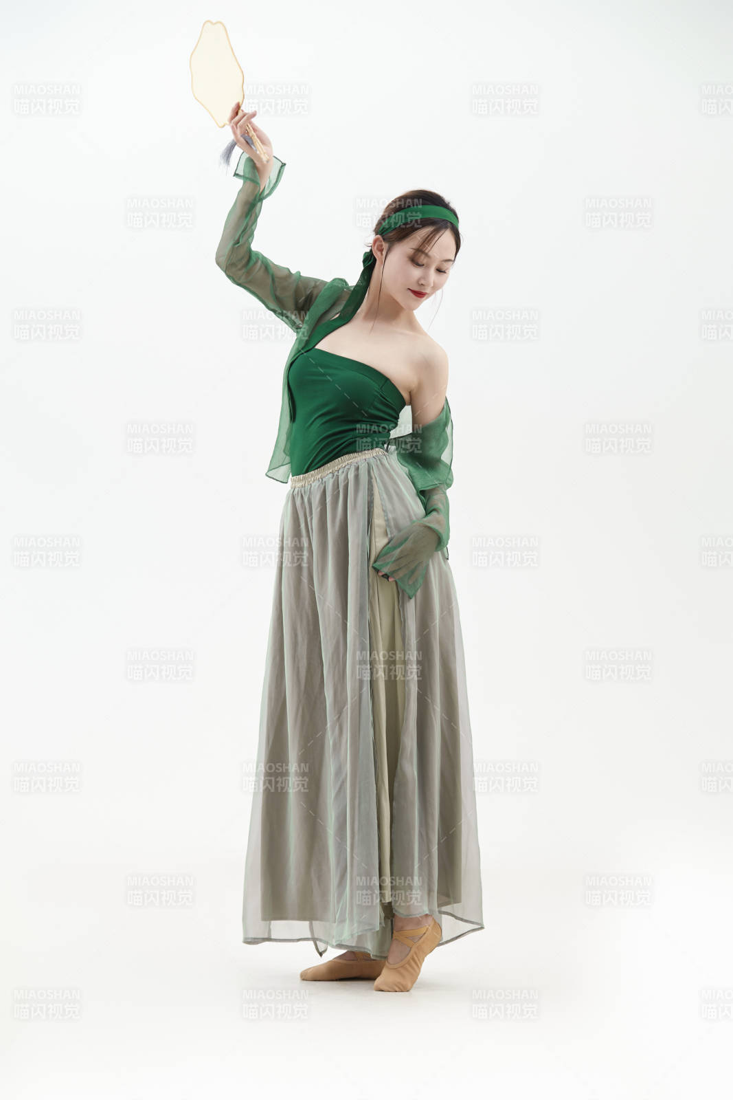 身穿青色古典舞蹈服装手拿蒲扇跳舞的少女图片