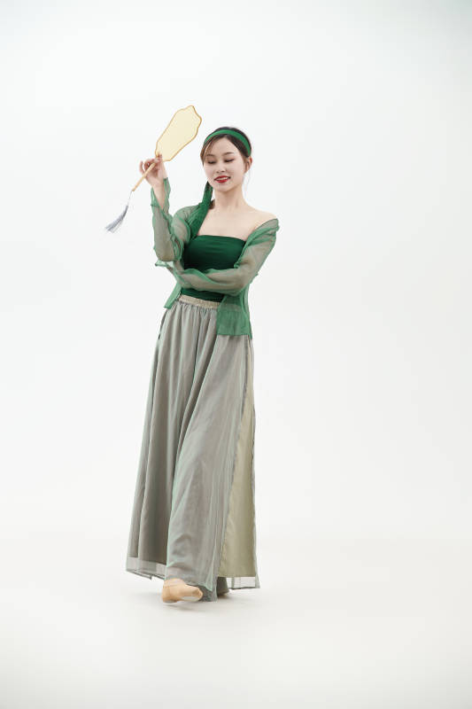 身穿青色古典舞蹈服装手拿蒲扇跳舞的少女图片