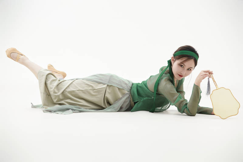 身穿青色古典舞蹈服装手拿蒲扇跳舞的少女图片