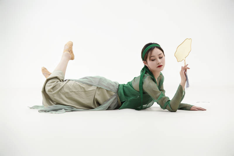 身穿青色古典舞蹈服装手拿蒲扇跳舞的少女图片