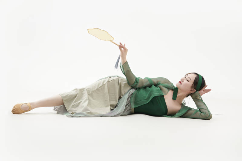 身穿青色古典舞蹈服装手拿蒲扇跳舞的少女图片