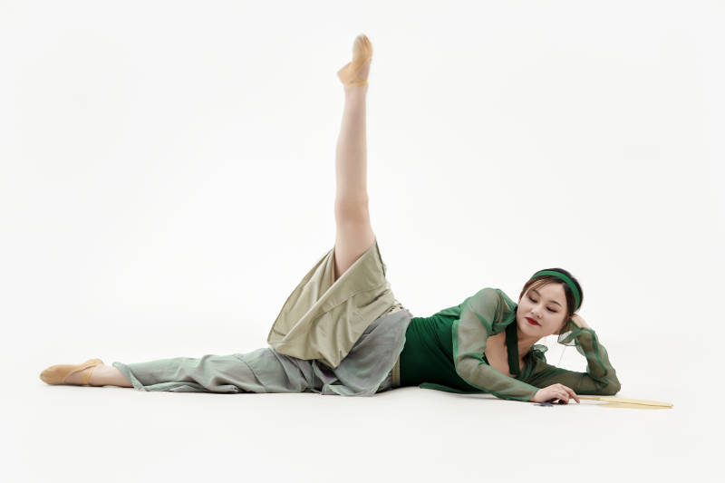 身穿青色古典舞蹈服装手拿蒲扇跳舞的少女图片